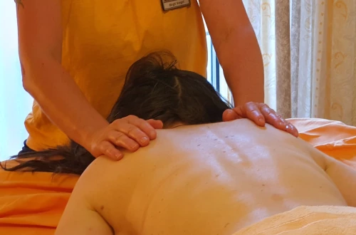 Rücken einer Massagepatientin mit Masseurin